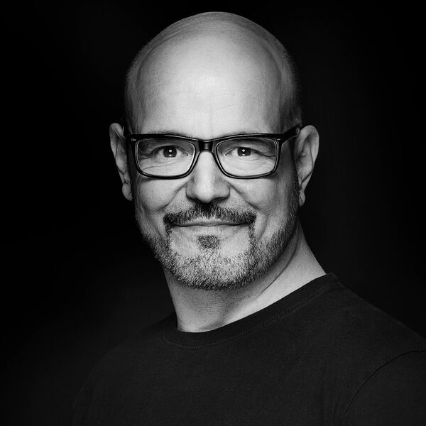 Portraitfotografie von kurzhaarigem Mann mit Brille und 3-Tagebart