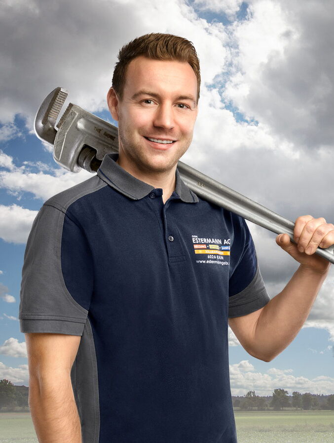 Mitarbeiterfotografie von Handwerker mit blauem T-Shirt und grossem Rollgabelschlüssel