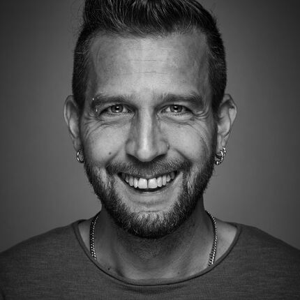 Portraitotografie von Mann mit Bart, und silberner Halskette und Ohrringe