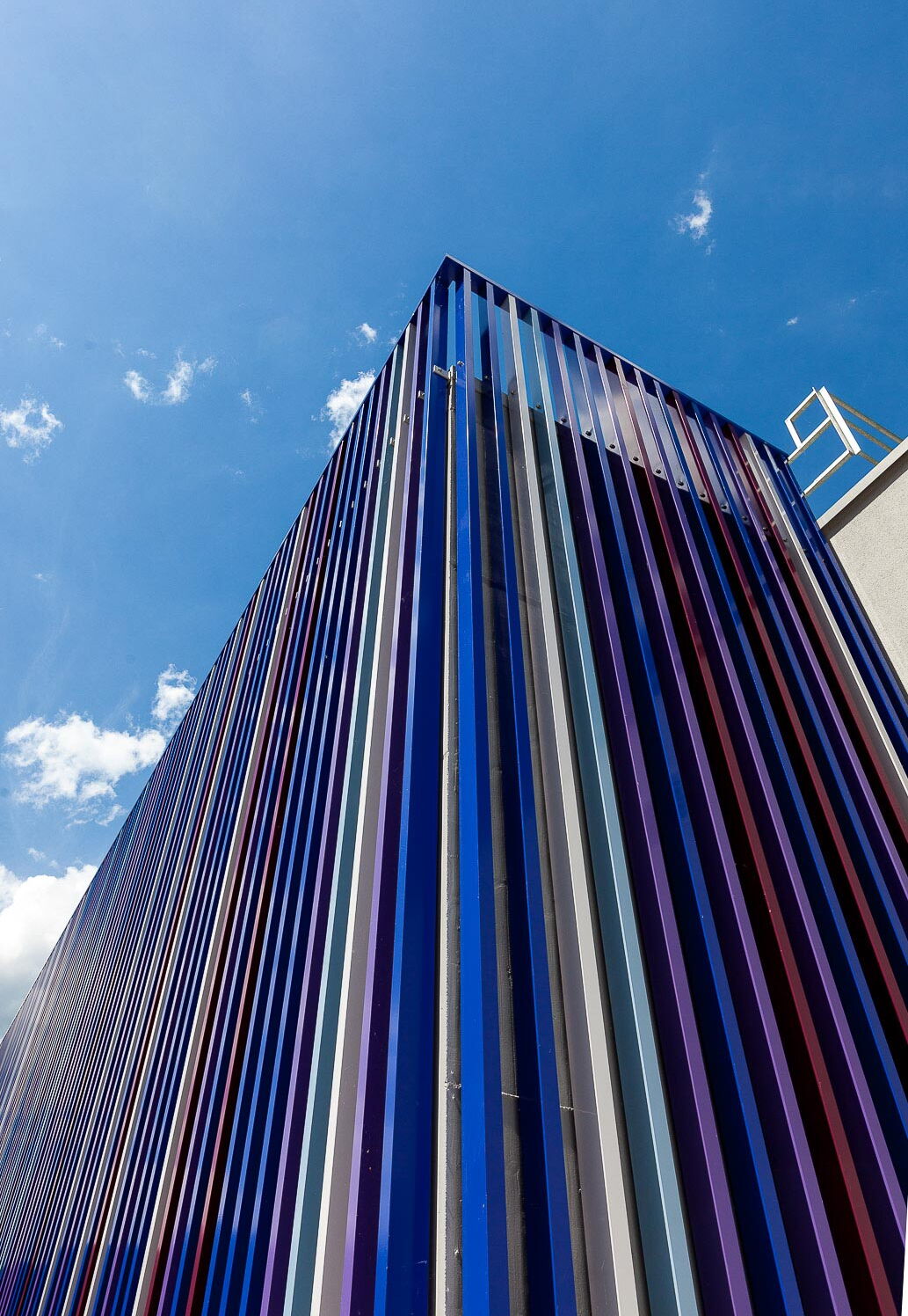 Industriefotografie: Farbige Stahlsäulen als Fassadenverkleidung von grossem Klärbecken