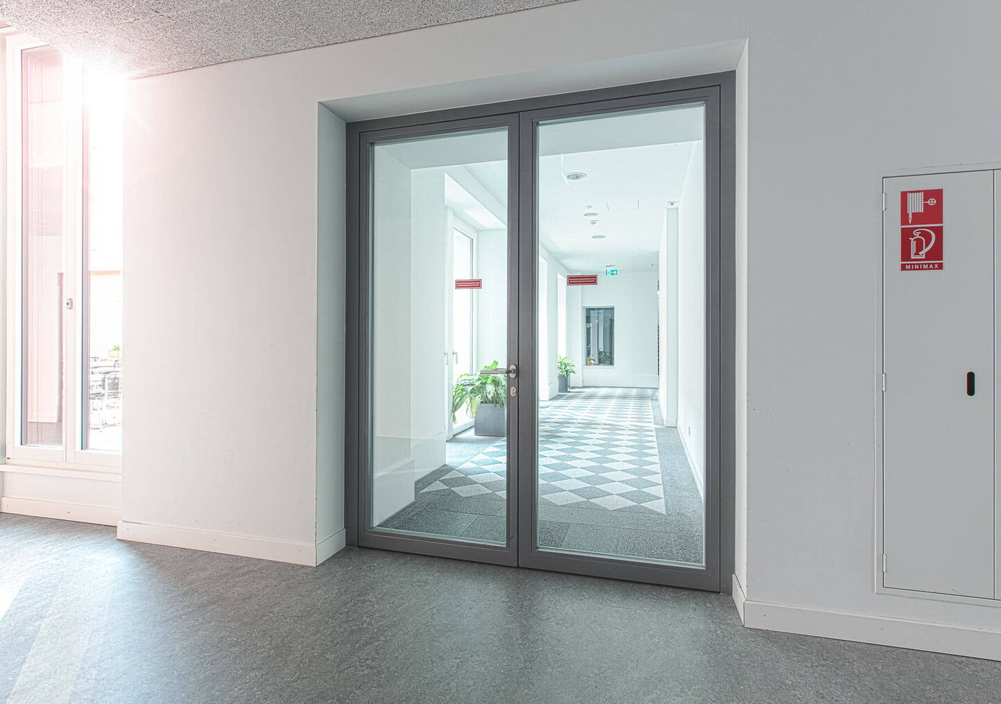 Industriefotografie: Doppelflüglige Brandschutztür mit Glaseinsatz in weisser Zarge