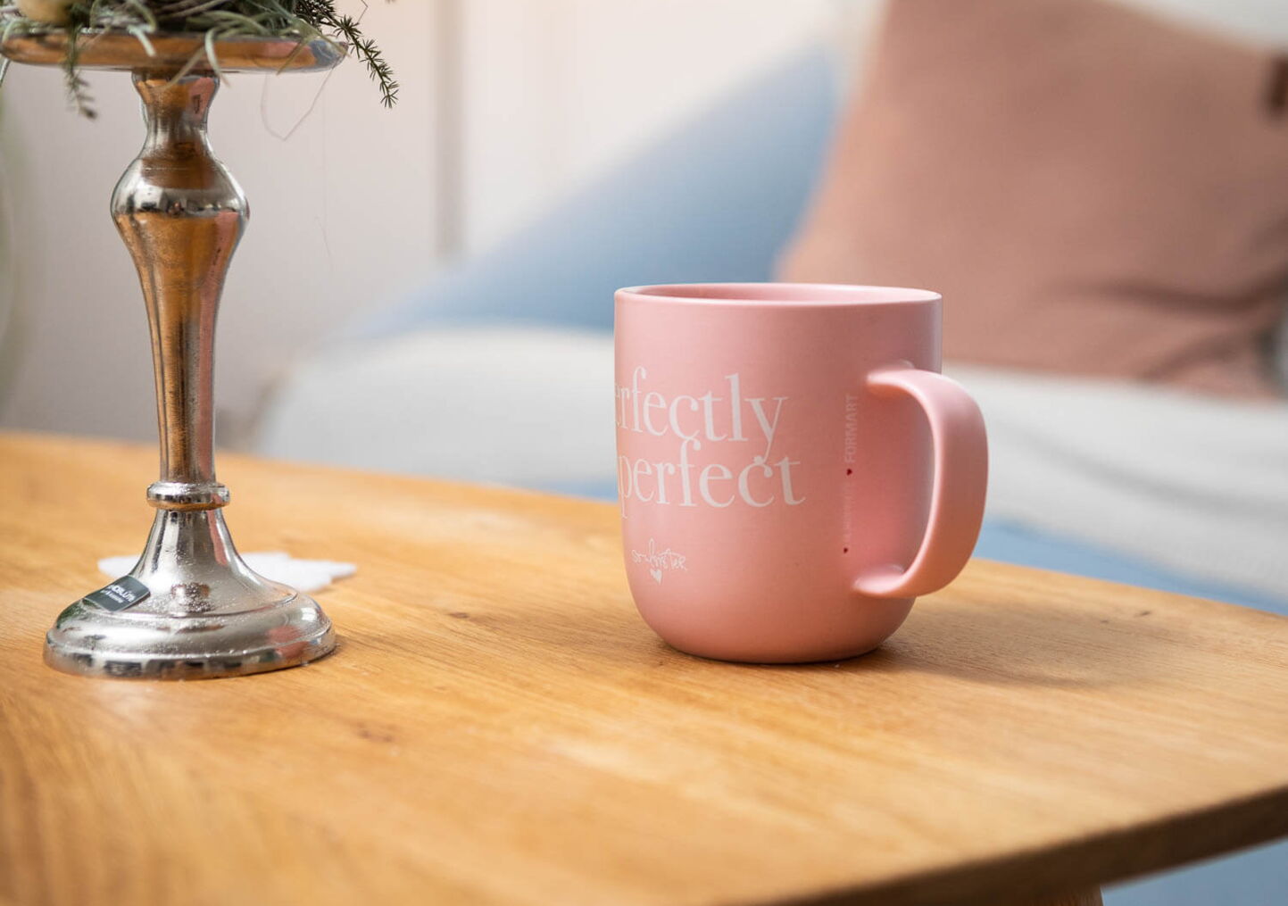Stimmungsfotografie von Tisch mit rosa Tasse mit weisser Aufschrift Perfect