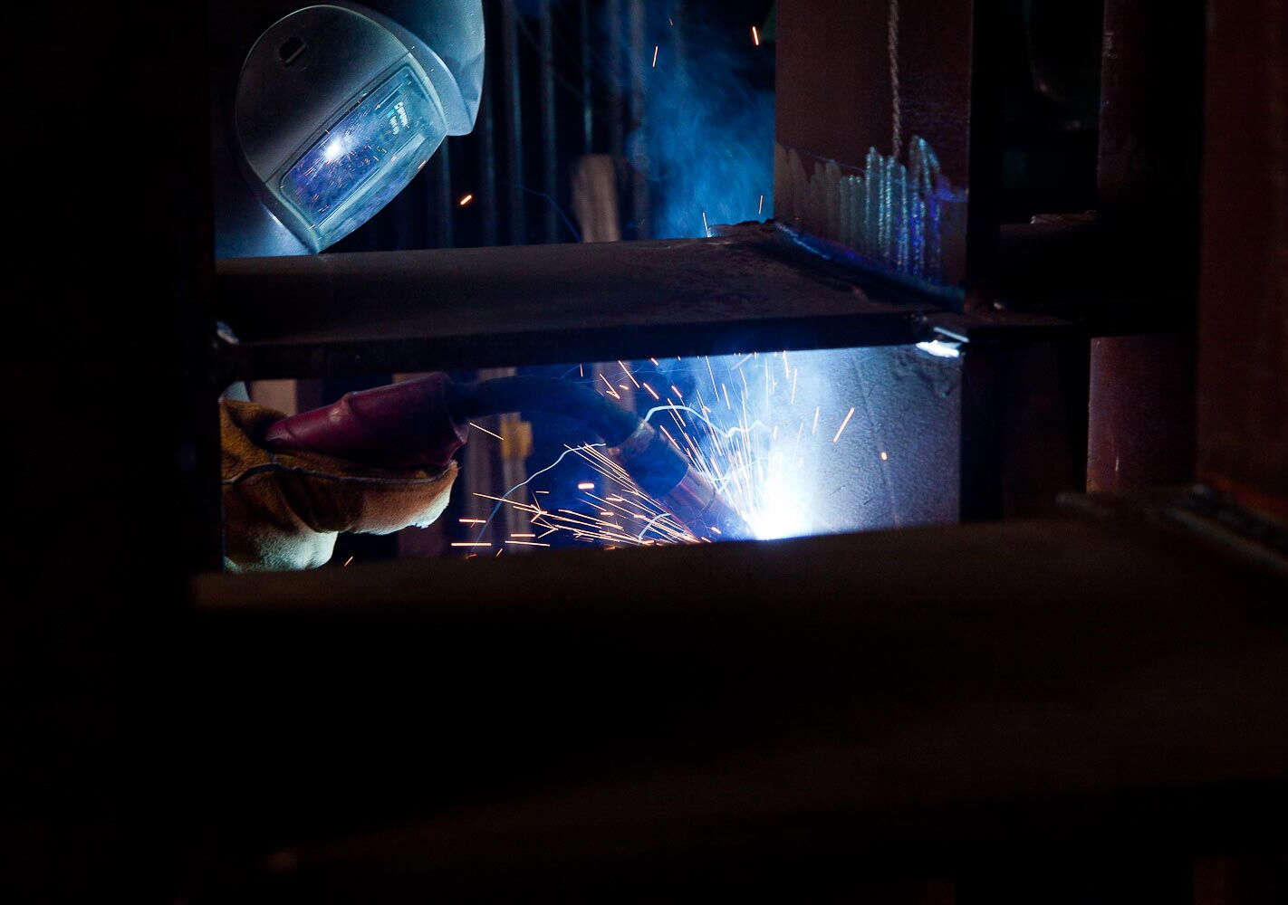 Industriefotografie: Schweisser mit Schild und Schweissanlage