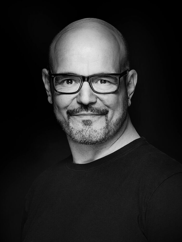 Portraitfotografie von kurzhaarigem Mann mit Brille und 3-Tagebart